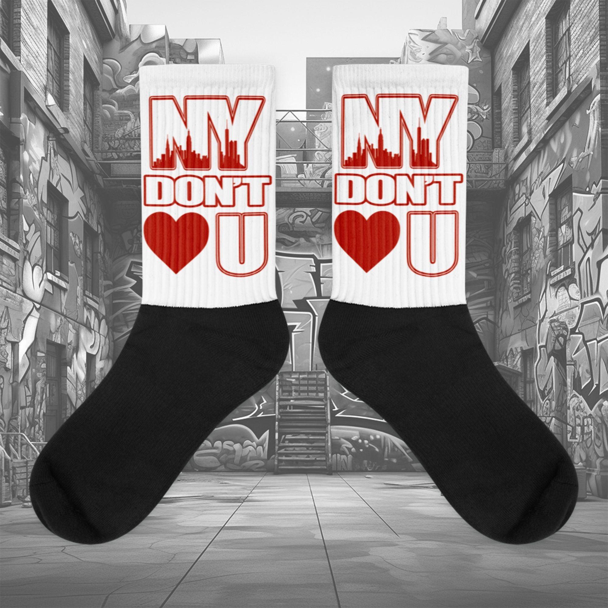 Showcases the view of the socks, highlighting the vibrant ' NY Don’t Love U ' design, which perfectly complements the Air Jordan 11 Cherry sneakers. The intricate pattern and color scheme inspired by the theme are prominently displayed. Focusing on the ribbed leg , cusioned bottoms and the snug fit of the socks. This angle provides a clear view of the texture and quality of the material blend.