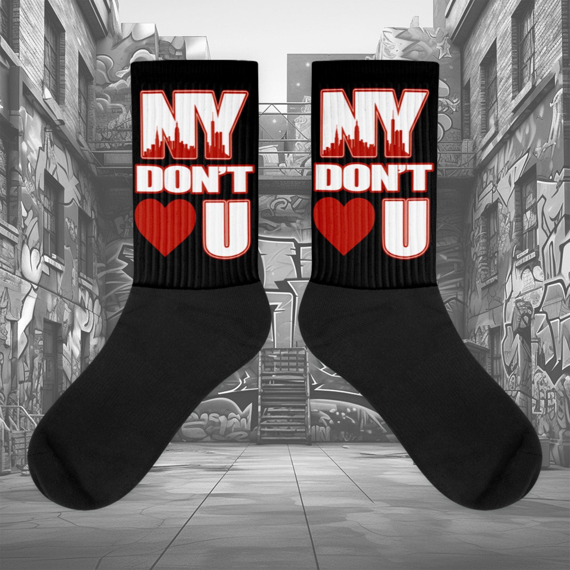 Showcases the view of the socks, highlighting the vibrant ' NY Don’t Love U ' design, which perfectly complements the Air Jordan 11 Cherry sneakers. The intricate pattern and color scheme inspired by the theme are prominently displayed. Focusing on the ribbed leg , cusioned bottoms and the snug fit of the socks. This angle provides a clear view of the texture and quality of the material blend.