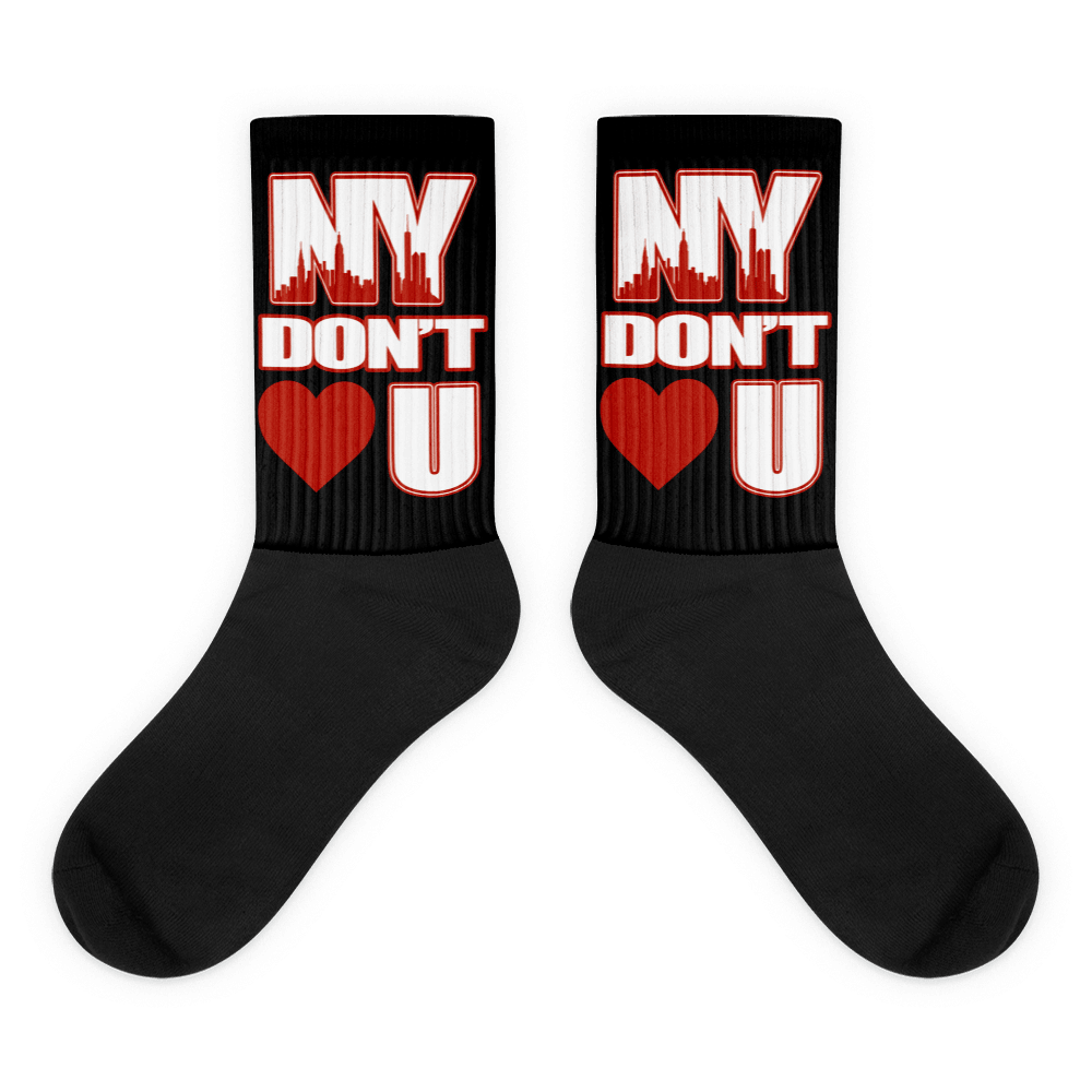 Showcases the view of the socks, highlighting the vibrant ' NY Don’t Love U ' design, which perfectly complements the Air Jordan 11 Cherry sneakers. The intricate pattern and color scheme inspired by the theme are prominently displayed. Focusing on the ribbed leg , cusioned bottoms and the snug fit of the socks. This angle provides a clear view of the texture and quality of the material blend.