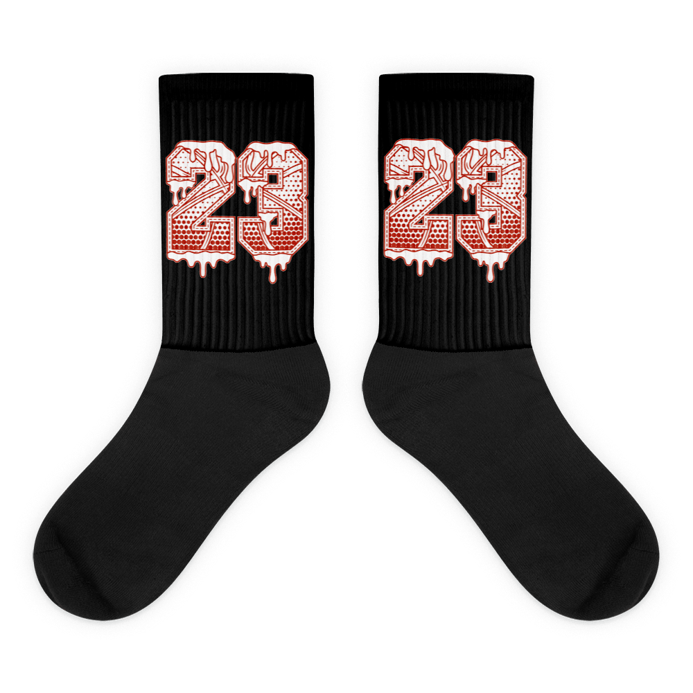 Showcases the view of the socks, highlighting the vibrant ' 23 Ball ' design, which perfectly complements the Air Jordan 11 Cherry sneakers. The intricate pattern and color scheme inspired by the theme are prominently displayed. Focusing on the ribbed leg , cusioned bottoms and the snug fit of the socks. This angle provides a clear view of the texture and quality of the material blend